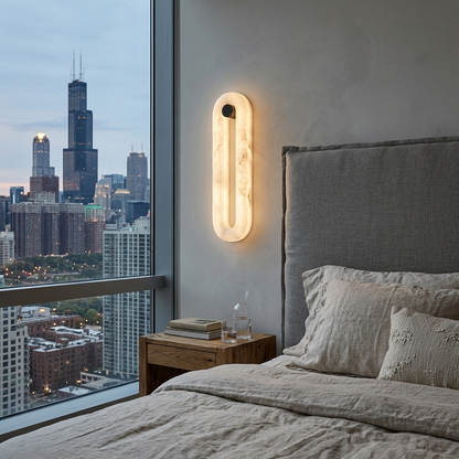 Aquila alabaster capsule wall sconce beside a bed in a Chicago apartment