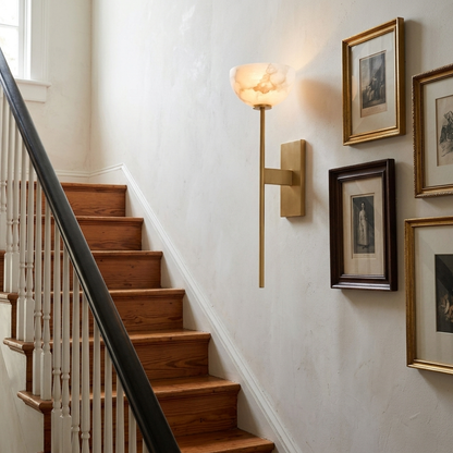 Caelan alabaster cup wall sconce in gold along a staircase in a Charleston home