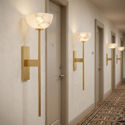 Caelan alabaster cup wall sconces in gold along a Denver hotel corridor