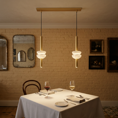 Brontee 2-light linear alabaster pendant in gold over a table in a Charleston restaurant