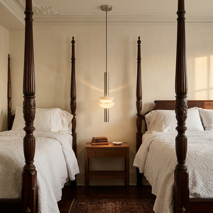 Brontee single alabaster column pendant in nickel beside a bed in a Savannah hotel room