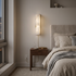 Cerise Carved Alabaster Plug In LED Wall Sconce 13.8 in. in gold beside the bed in a city apartment bedroom